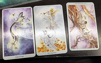 Three tarot cards from the Shadowscapes Tarot by Stephanie Law. Left to right, the cards are the Eight of Cups, Judgement, and The Hanged Man, reversed.